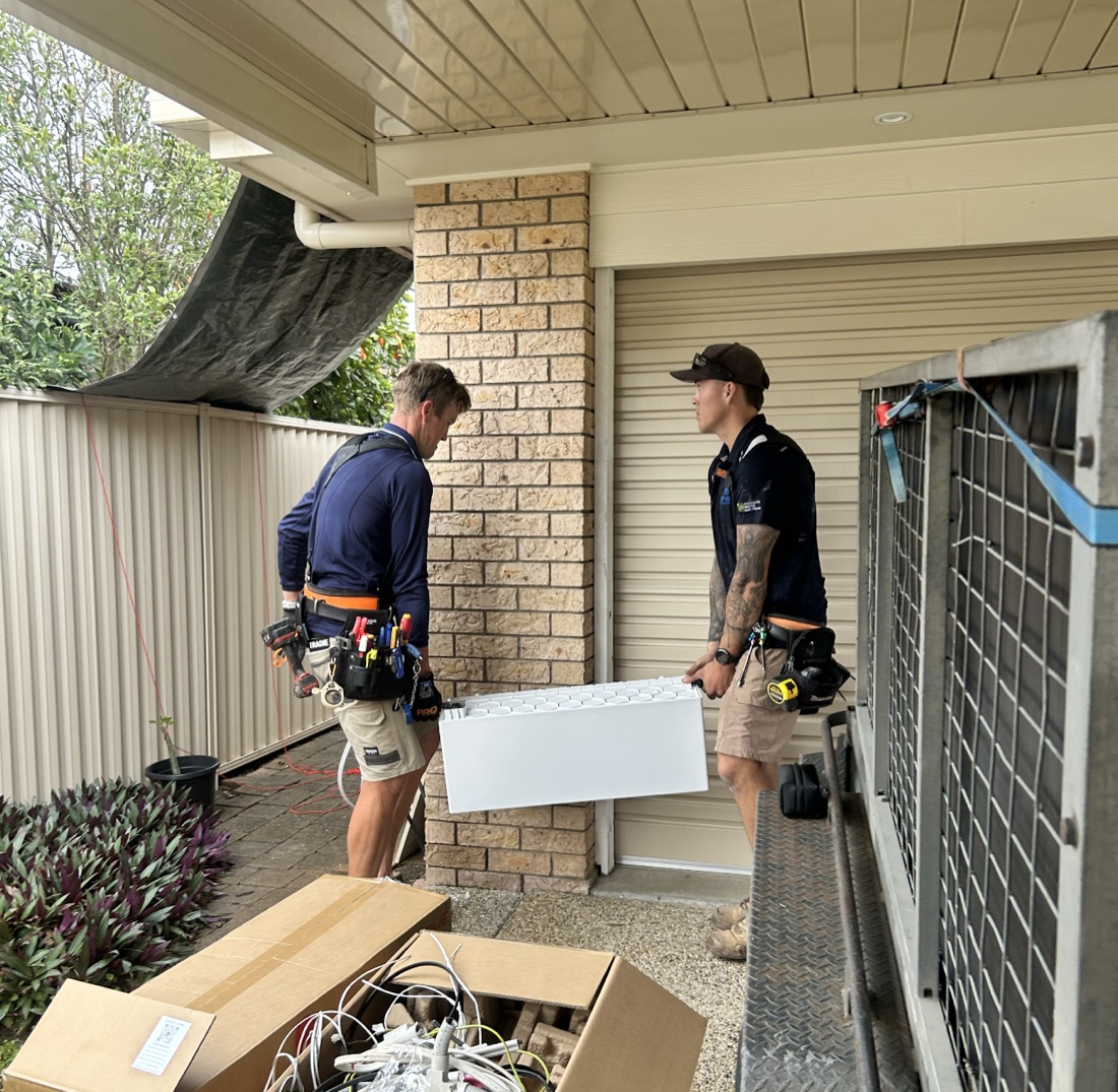 EFS Solar's own installers carrying a home battery on a job